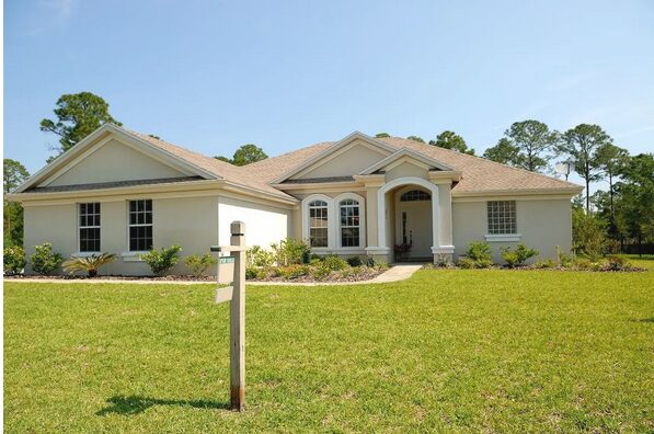 A White and Brown Concrete Bungalow Under Clear Blue Sky