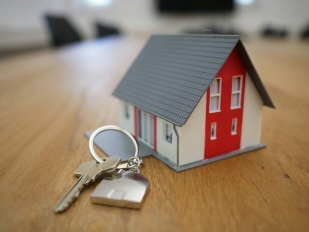 House keys placed next to a small dummy house
