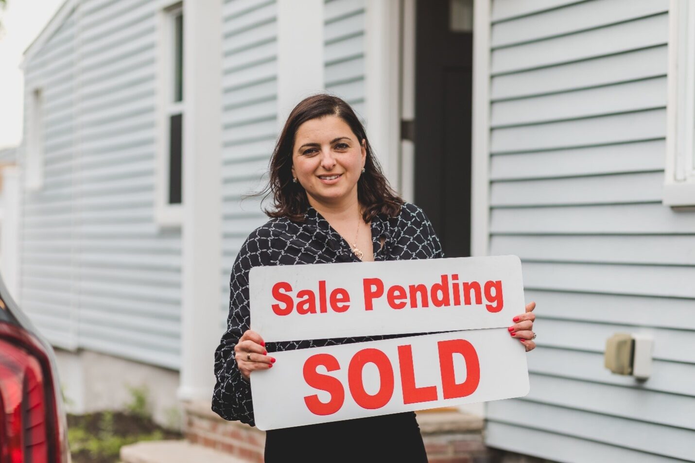 Realtor Holding a ‘Sale Pending’ Sign