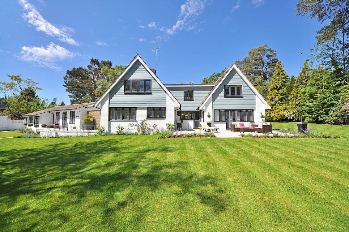 A white and gray house with a lawn 