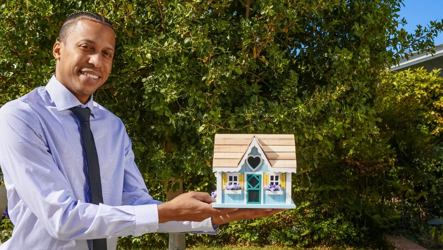 Realtor Holding a Miniature House