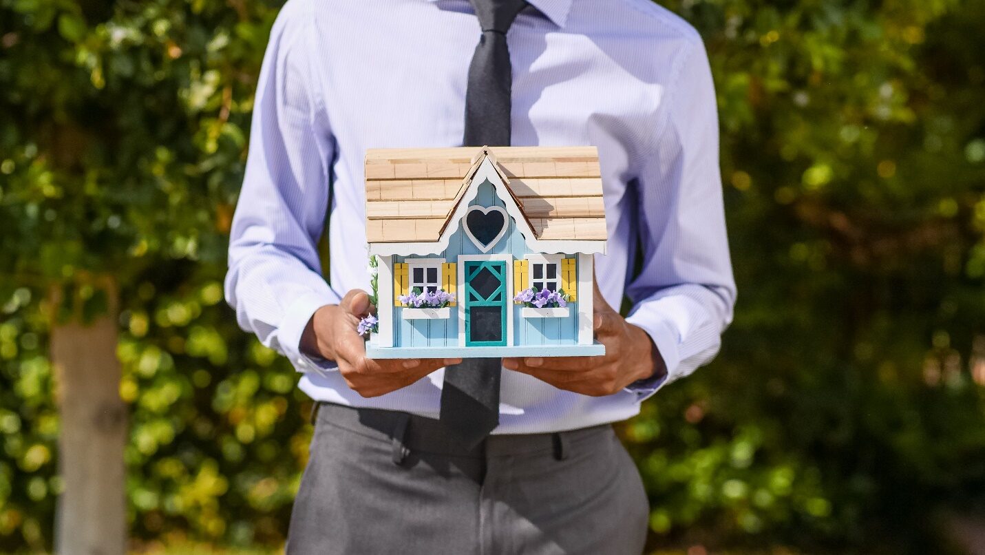 Realtor Holding a Miniature House