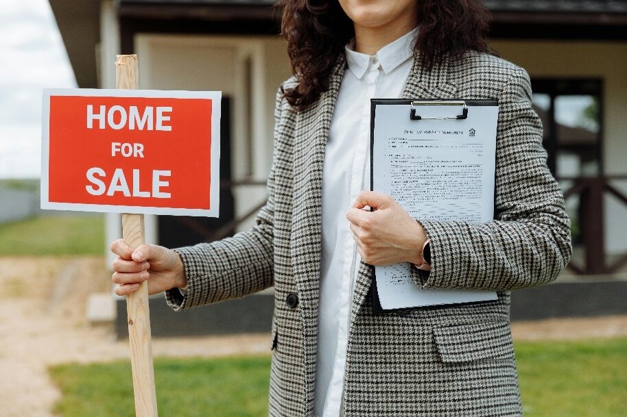A realtor holding a sign