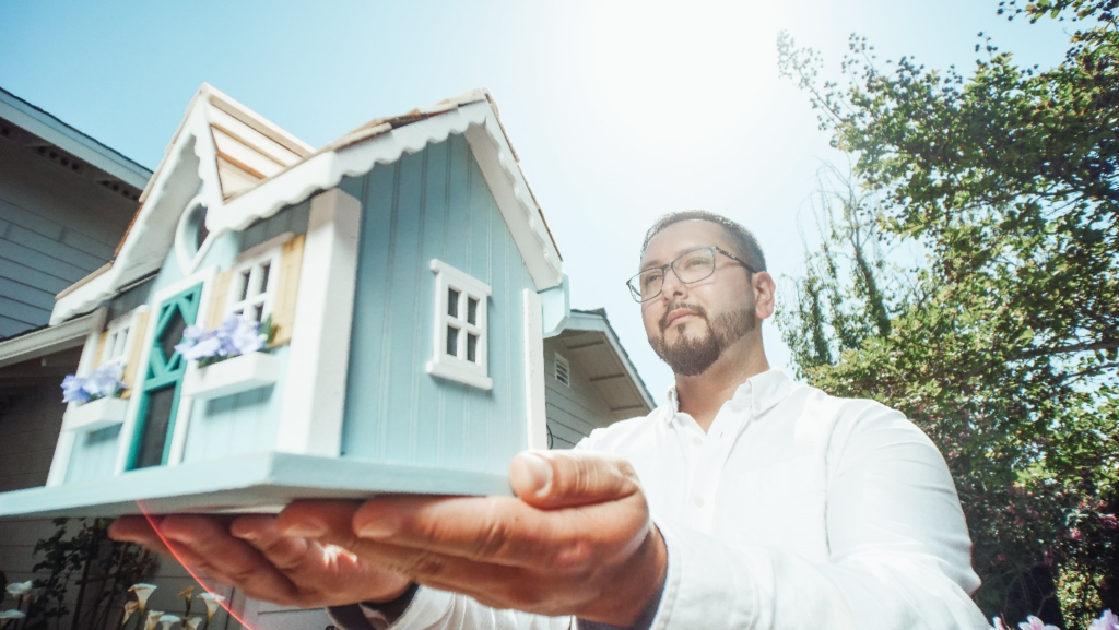 Realtor Holding a Miniature House