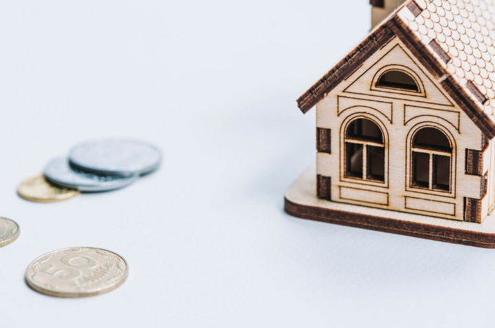 Miniature House Next To Coins