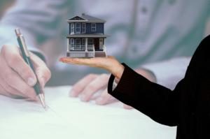 Realtor Holding a Miniature House