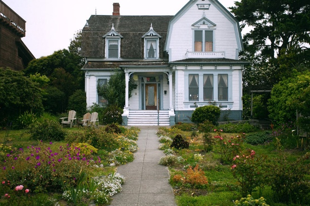 A well-maintained front yard with vibrant flowers and a freshly painted door