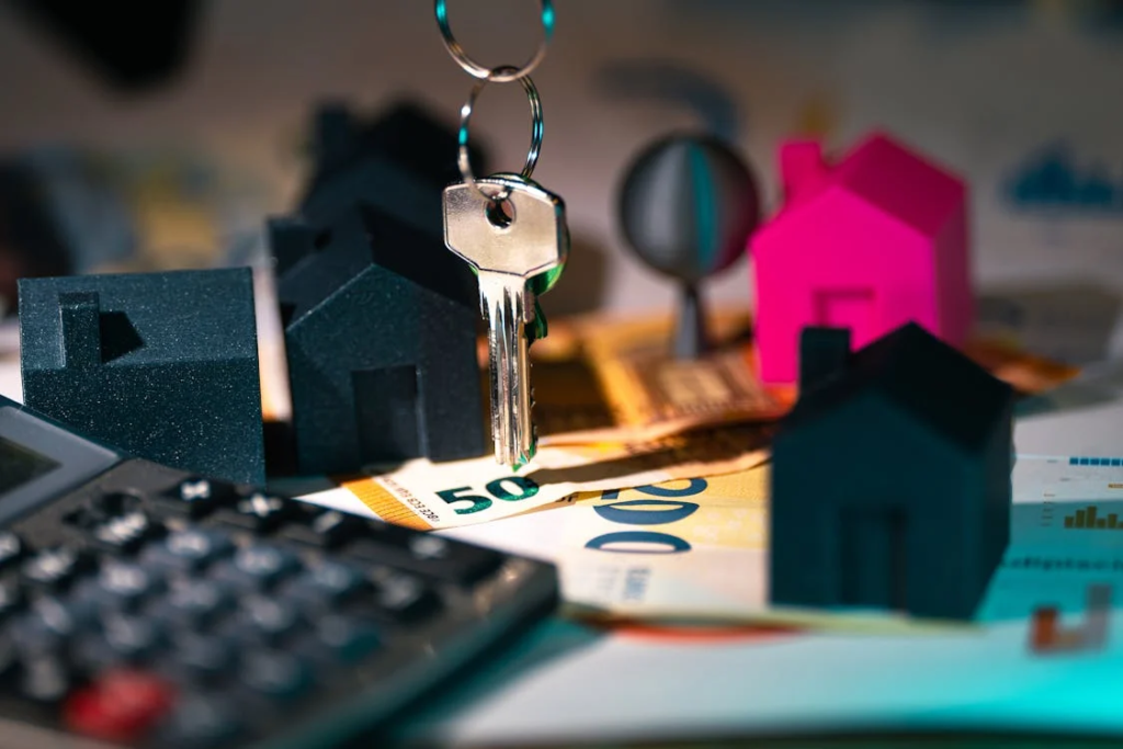 A stack of coins and a house model symbolizing hidden costs in home buying.