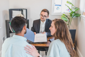 A real estate consultant discussing property options with a client in an office.