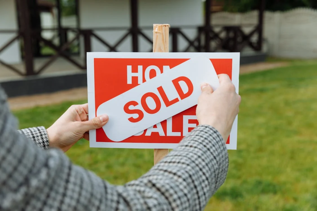 Real estate agent posting a sold sticker 