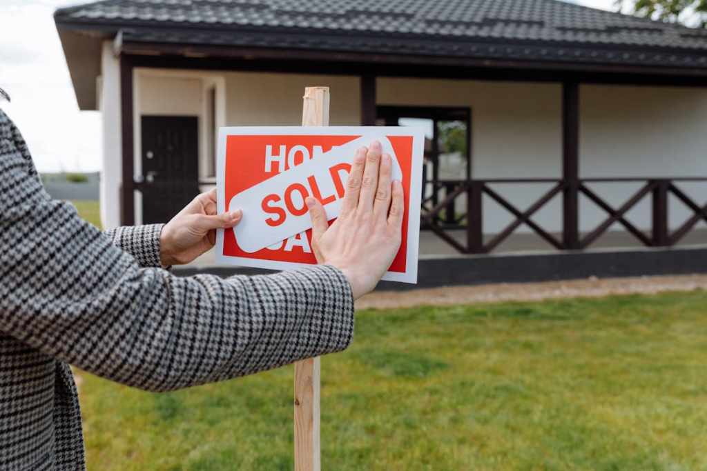 Real estate agent posting a sold sticker 