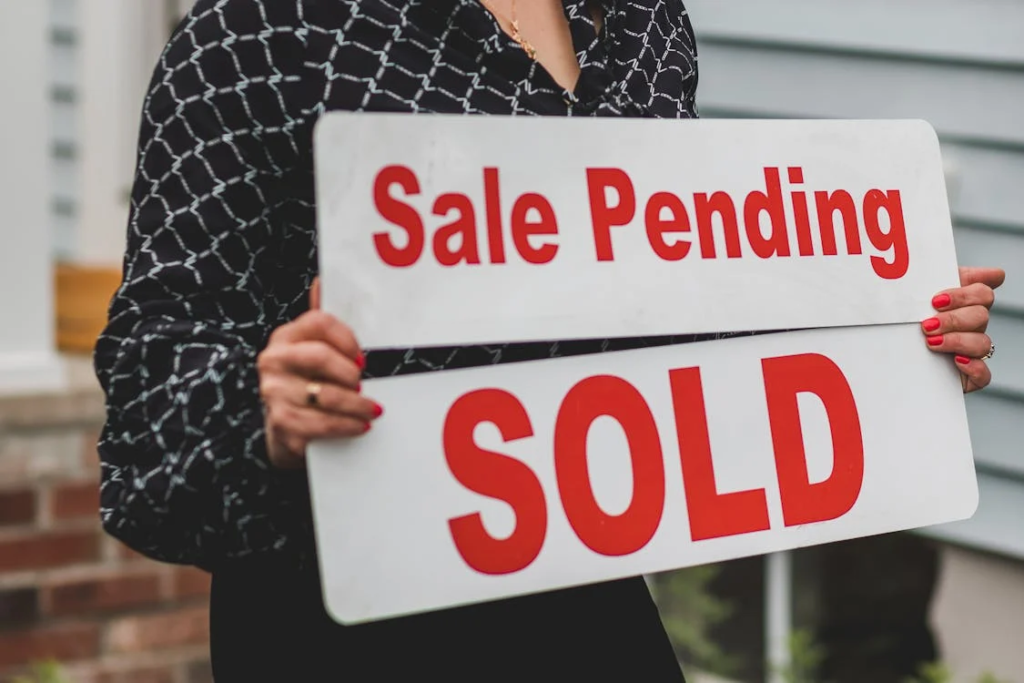 A real estate agent holding signages for property selling