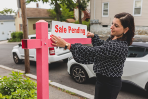 A woman attaching property selling signage