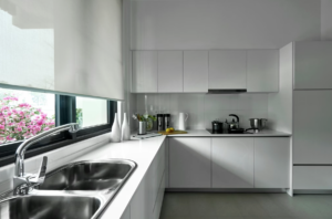 This photo shows a bright, clean modern kitchen with simple countertops and cabinets.