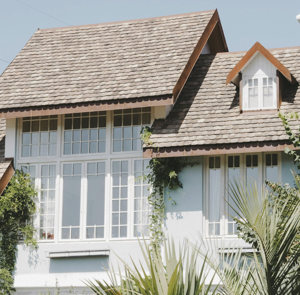 This photo shows a house roof with neatly arranged shingles viewed from the ground.