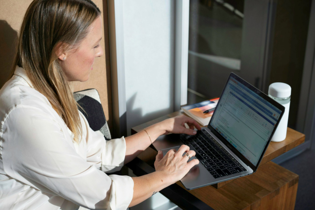 A woman typing on a laptop keyboard