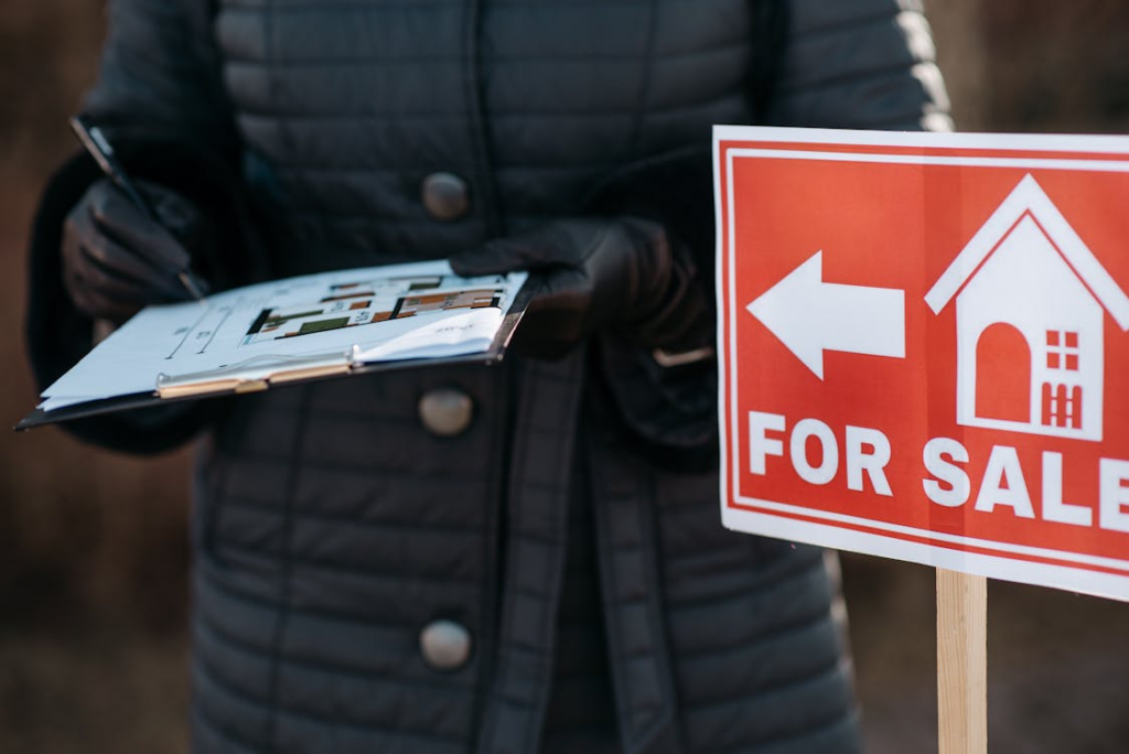 a for sale signage with a realtor holding a property plan