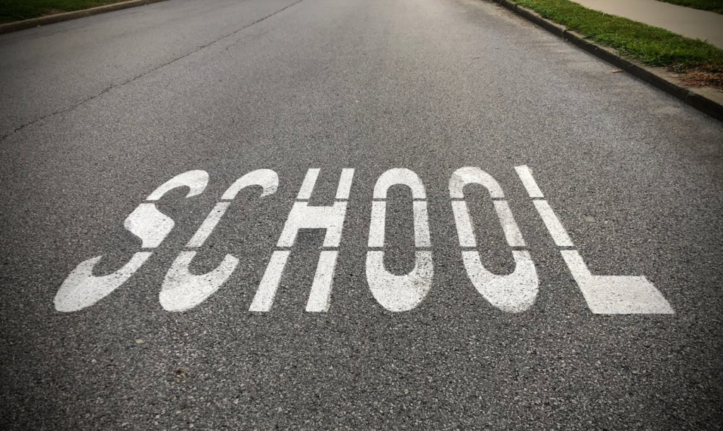 Road marking indicating a school zone affecting nearby home values