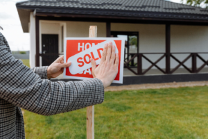 Realtor putting a “sold” sign