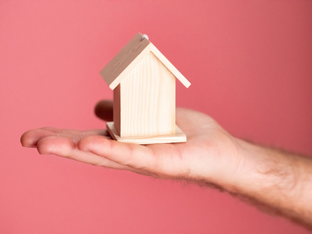 Realtor holding a miniature wooden house