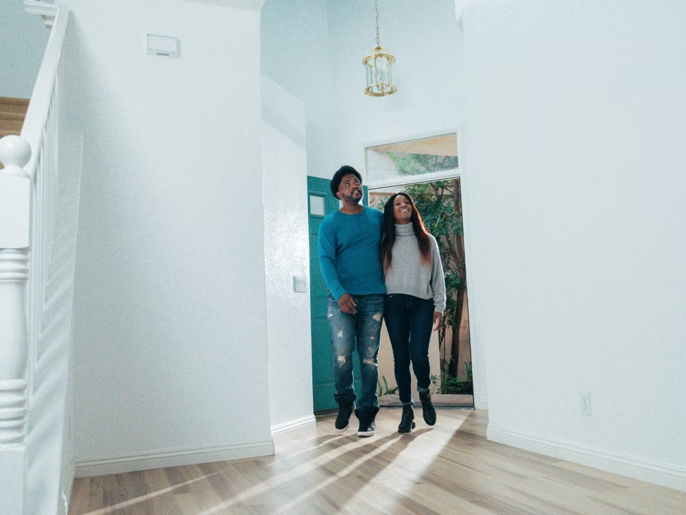Cheerful couple touring the interior of a home they are considering buying.